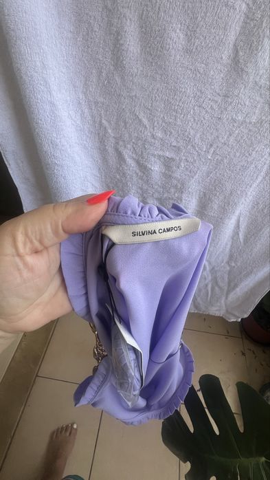 Blusa com alças de metal douradas.