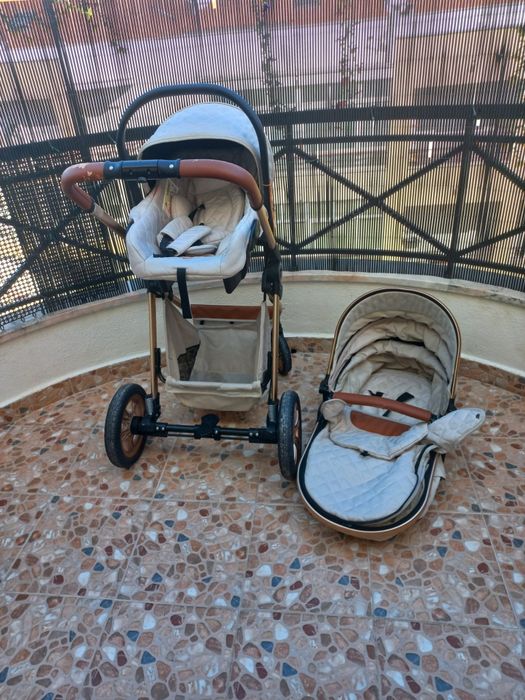Carrinho de bebé com mmarcas de uso no puxador.