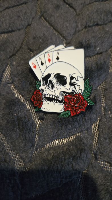 Przypinka karty i czaszka.