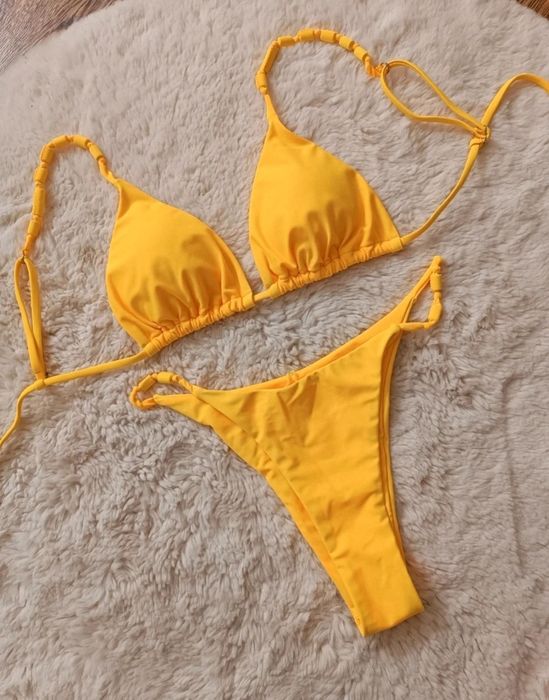 Nowy żółty strój kąpielowy typu bikini z nutką oryginalności.