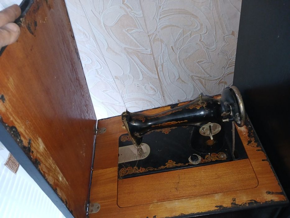 Швейная машинка с ножным приводом находится в тумбочке