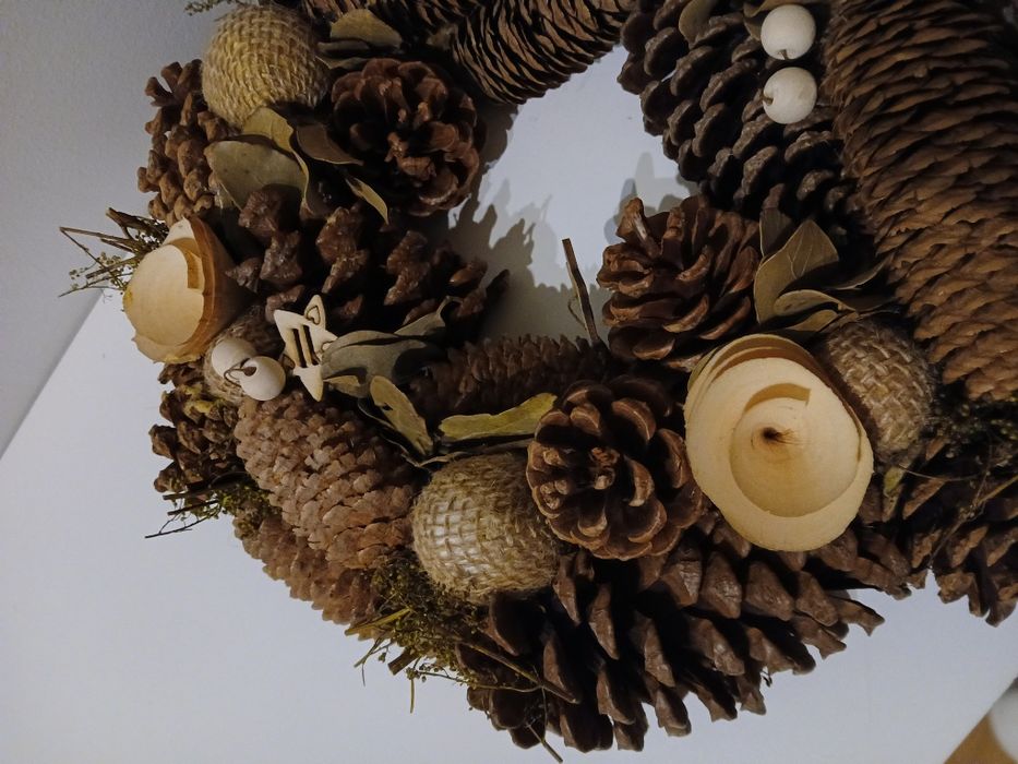Coroa com pinhas e decorações de madeira