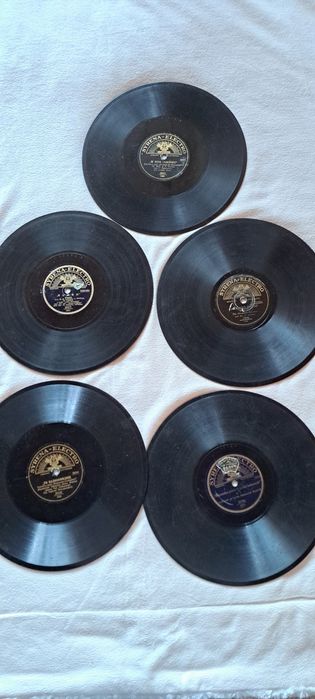 Zestaw 5 przedwojennych płyt gramofonowych 78 RPM wytwórni Syrena-Electro w stanie nieznanym, nieczyszczonym. Płyty są matowe i brudne.
