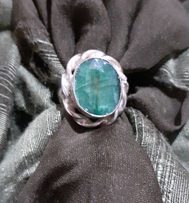 Anel em metal com pedra verde em destaque