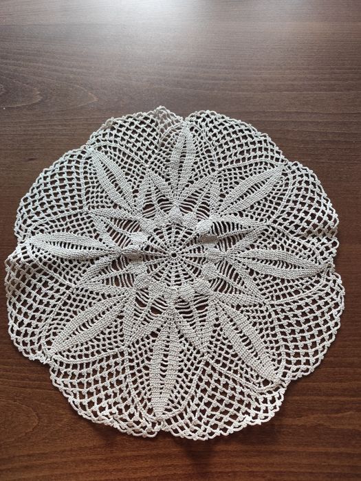 Okrągła, bawełniana serweta ręcznie robiona na szydełku.