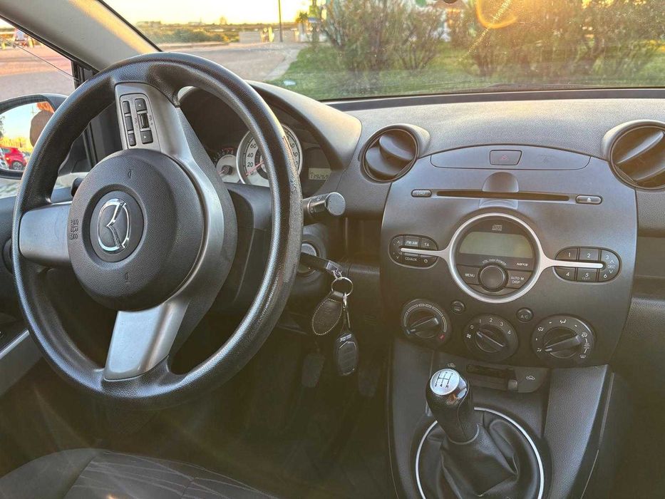 Mazda 2 de 2010, cor cinzenta, com cerca de 140.000 km.