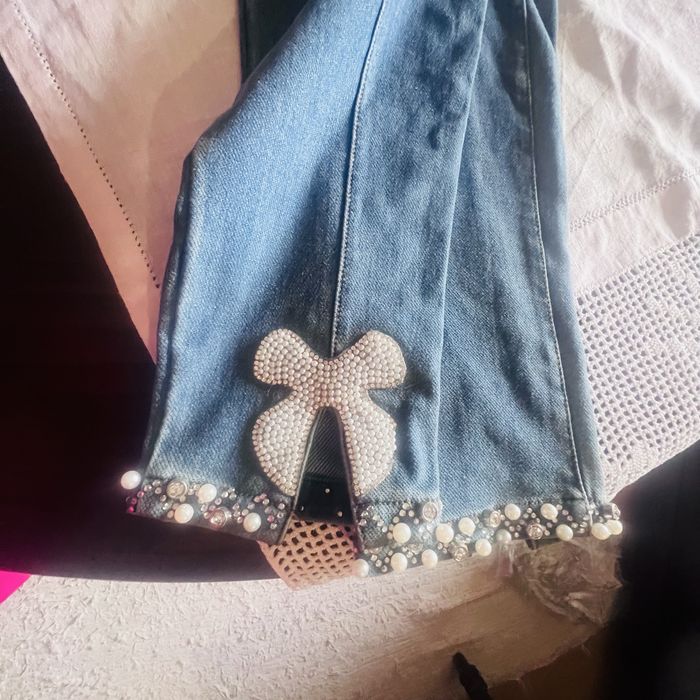 calça ganga com feitios de brilhantes