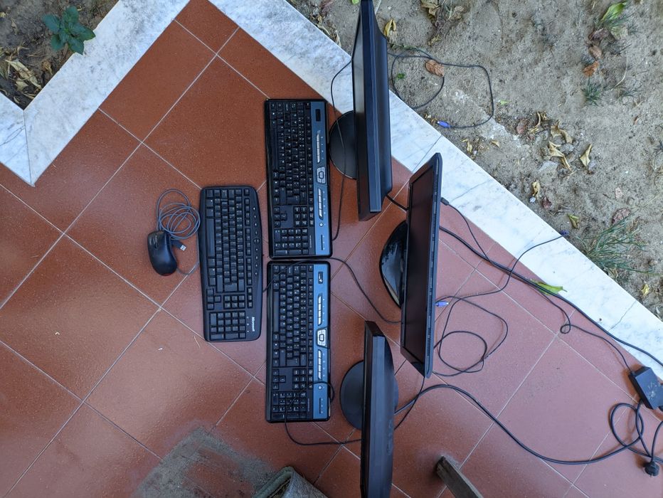 3 monitores com teclados e rato