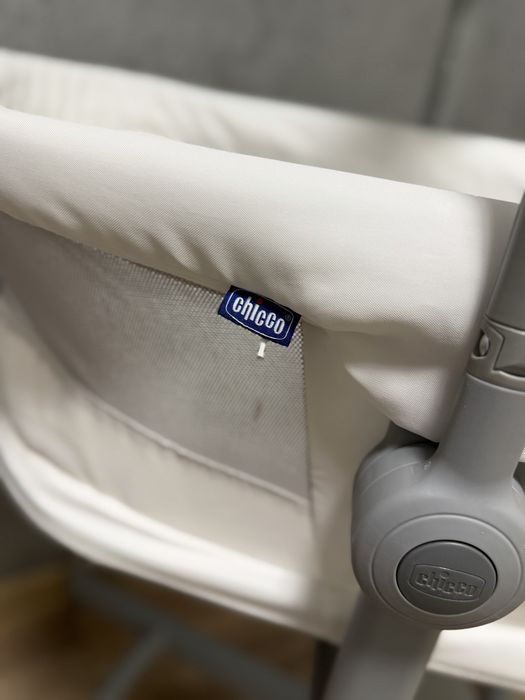Кроватка-стульчик Chicco Baby Hug Air 4-в-1 в белом цвете с сетчатыми боковинами для вентиляции.