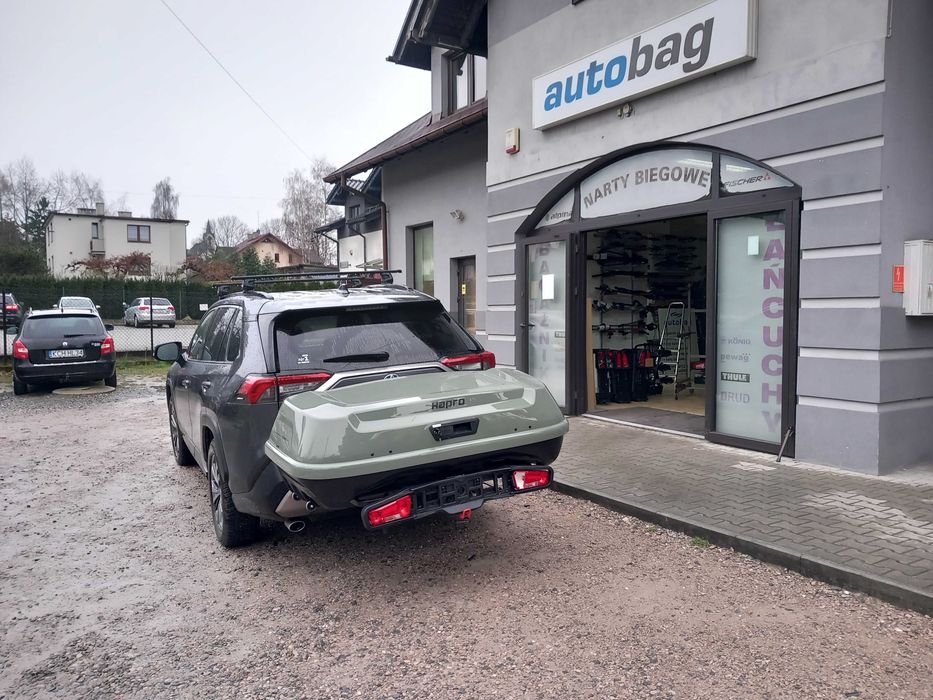 Box montowany na hak holowniczy  Hapro Boxer 420 L - mocny, solidny w kolorze oliwkowej zieleni. Odchylany - umożliwia dostęp do bagażnika samochodu