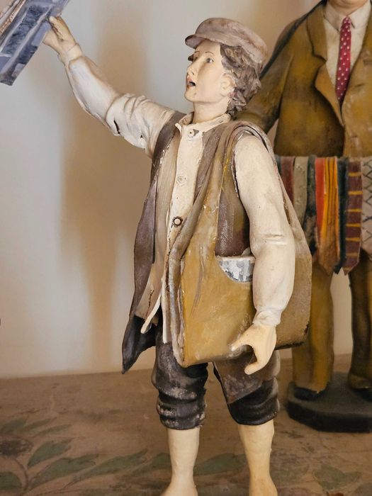 Estatueta de barro – olha o jornal