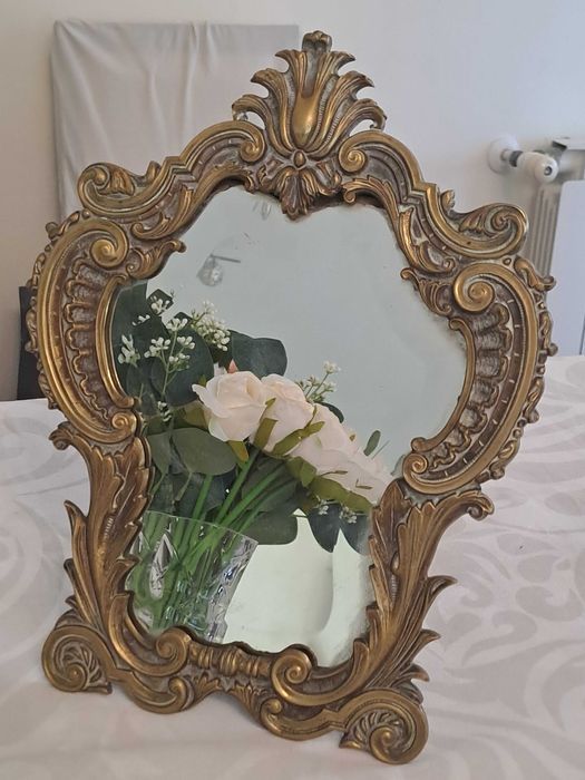 Espelho de mesa com moldura ornamentada em estilo barroco.