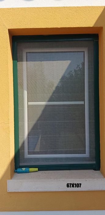 Janelas em alumínio, brancas e verdes, com veda luz interior.