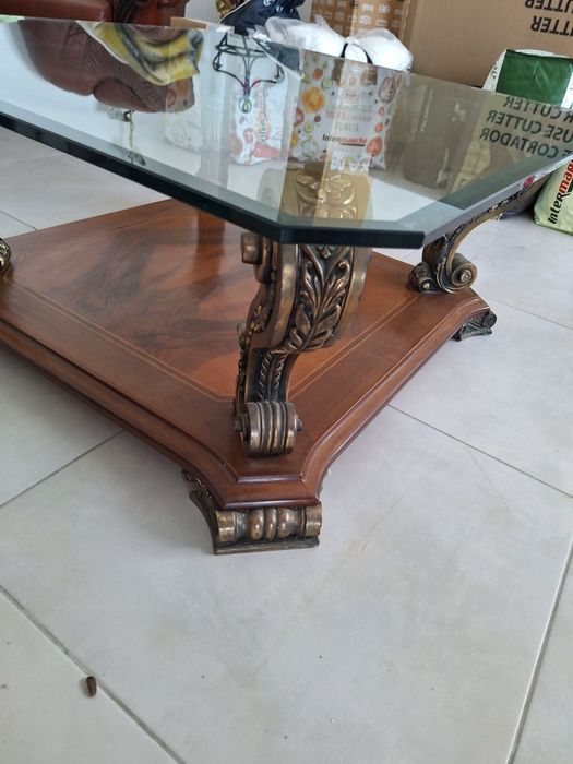 Mesa de centro clássica com tampo de cristal.