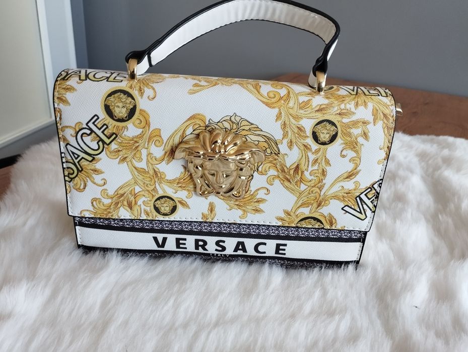 Biała torebka ze złotą aplikacją Versace.