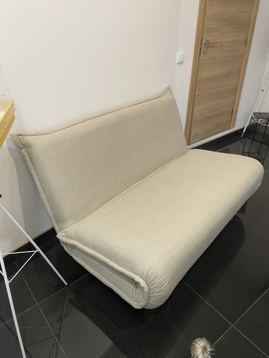 Sofá cama com duas almofadas.