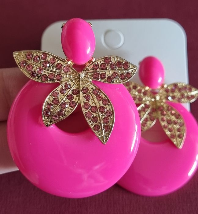Brincos em acrílico, de pico, em rosa fucsia e apontamentos dourados.