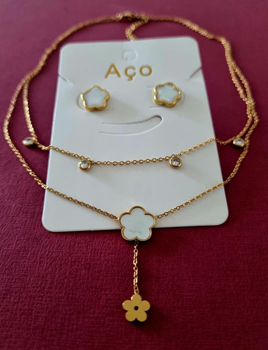 Conjunto dourado (colar duplo e brincos), em aço, com flores brancas em madrepérola.