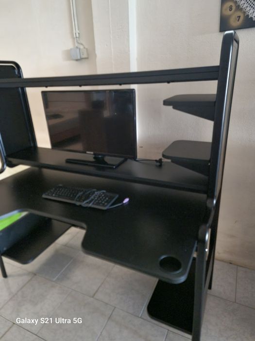 Secretaria preta com prateleiras e pés de ferro e laterais de ferro