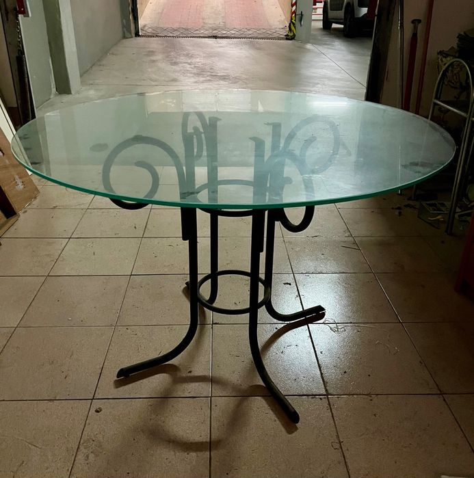 Mesa redonda em vidro com pés em ferro trabalhado