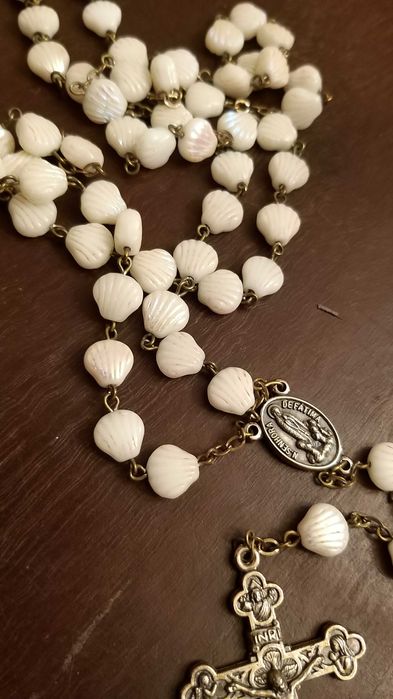 caixa prateada com marca e terço