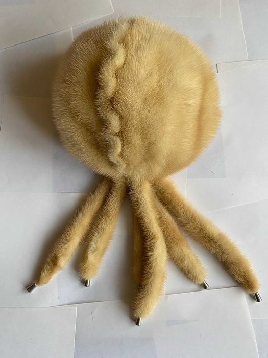 Шапка норковая кремового цвета с хвостиками на подкладке.