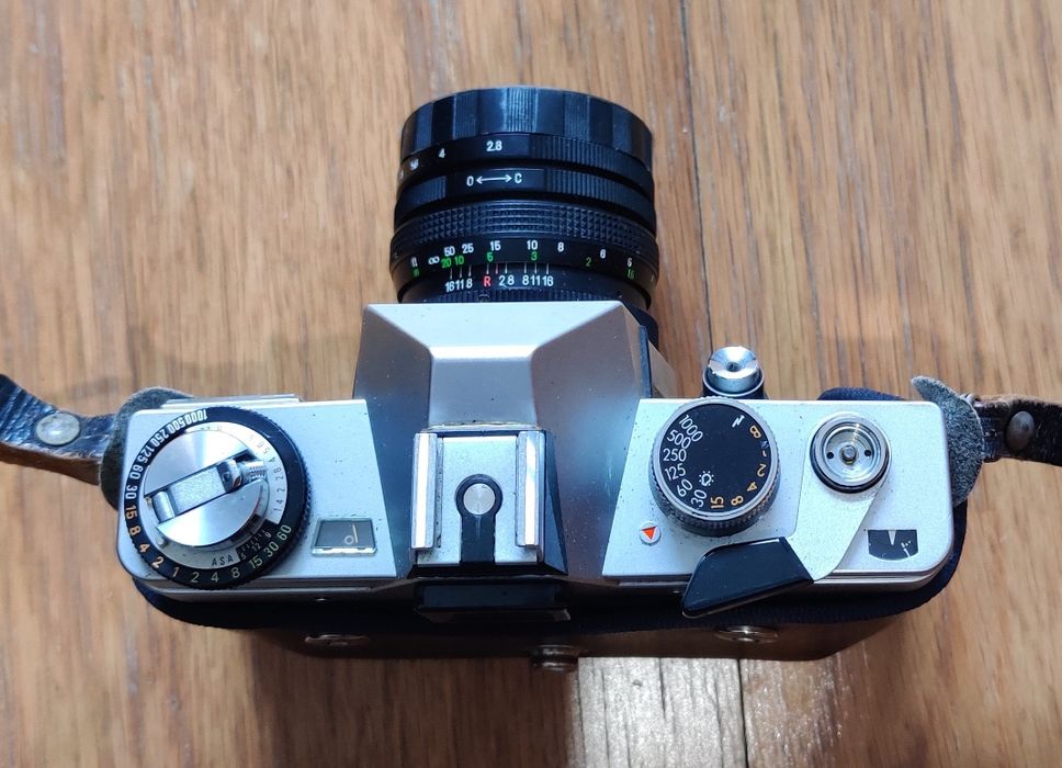 Máquina fotográfica antiga e lentes.