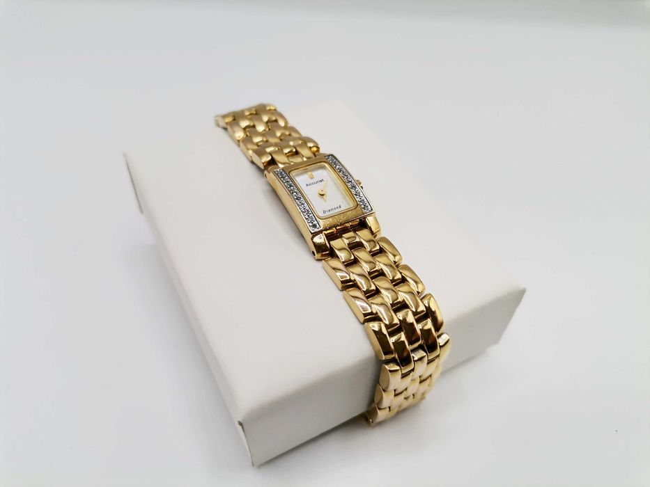 Zegarek damski z drobnymi brylantami na kopercie.