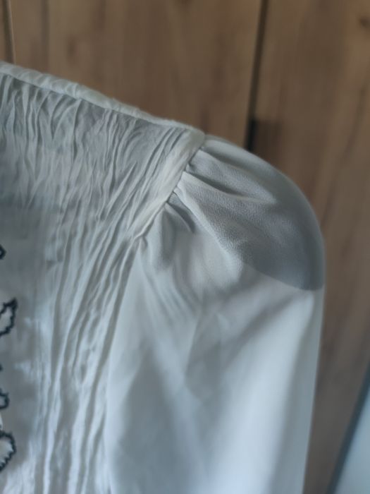 Biała bluzka z pięknym żabotem.