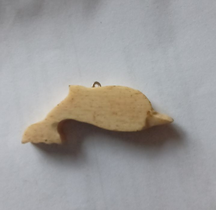Golfinho  em osso de baleia.
Tem uma pintura alusiva à ilha do Pico. Data de 1989.
Mede aproximadamente 5 cm.