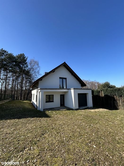 Nowoczesny biały dom w otoczeniu lasu – stan surowy