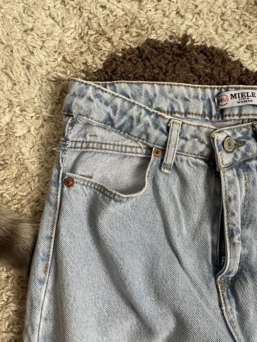 Джинси з заводськими вирізами на карманах mom