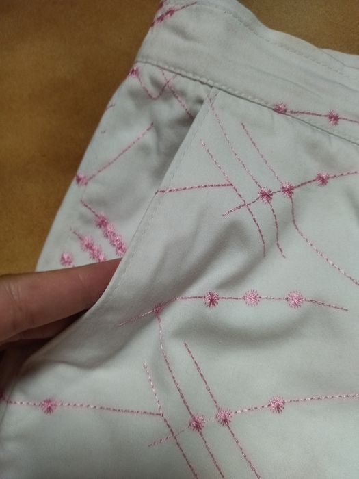 Calças brancas com bordado cor de rosa
