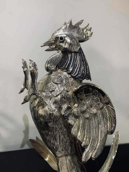 Galos em posicao de luta em prata assentes base madeira lacada.