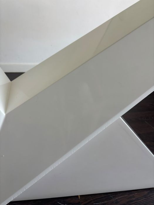 Mesa de vidro temperado com pé lacado branco.
