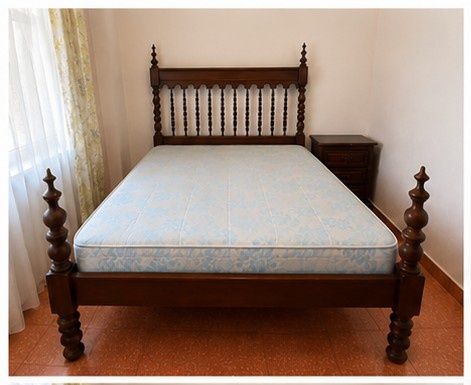 Cama casal e abajur de madeira