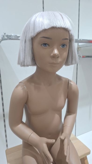 Manequim infantil sentado com cabelo e rosto realista