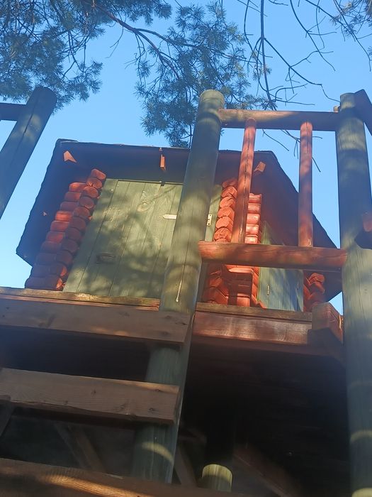 Domek dla dzieci, z zjeżdżalnią i piaskownicą.