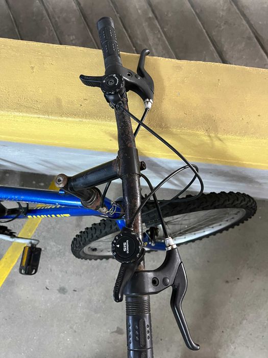 Bicicleta de montanha com cadeado e capacete, estado usado