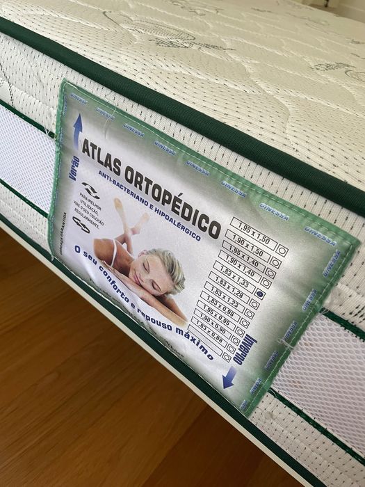 Cama lacada de branco e colchão ortopédico