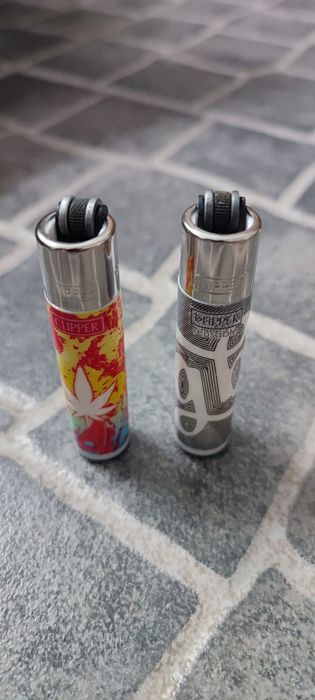 Conjunto de dois  Clipper Mini colecionáveis. Cada um tem um design único e vibrante.

- Um com padrão de folha  em vermelho e amarelo.
- Um com padrã