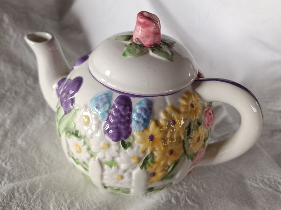 Bule em cerâmica pintado à mão com um padrão floral em relevo