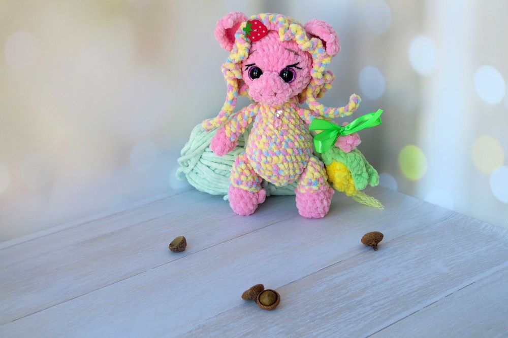 В'язана кольорова свинка в чепчику та з кукурудзою