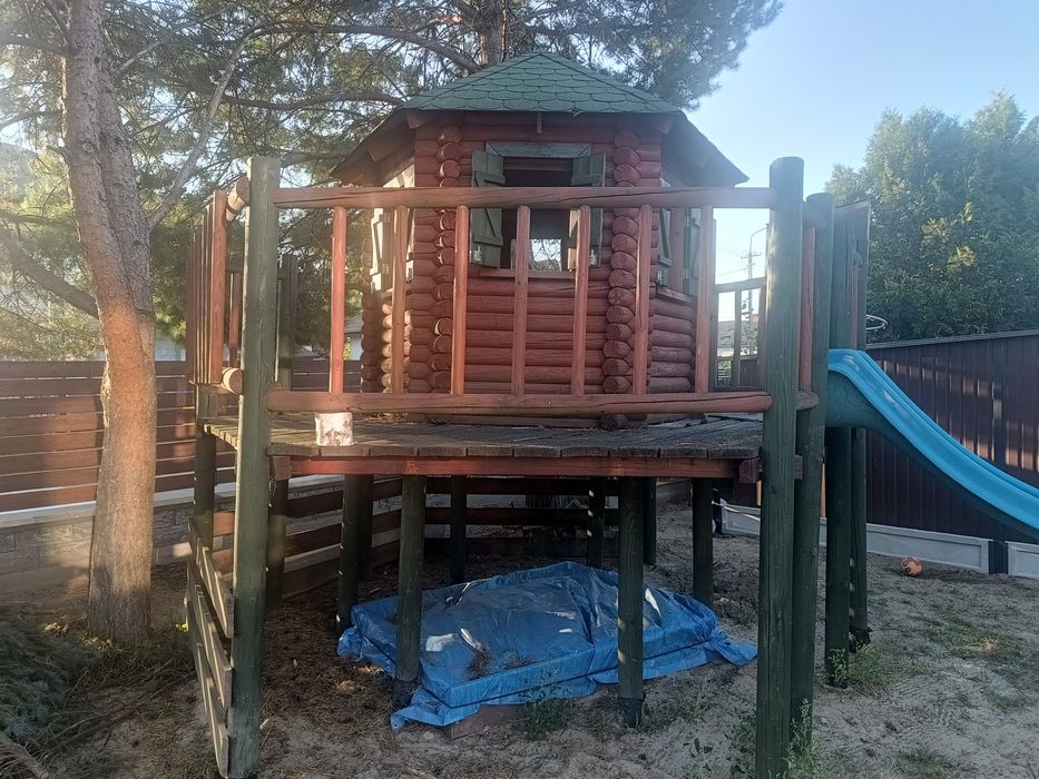 Domek dla dzieci, z zjeżdżalnią i piaskownicą.