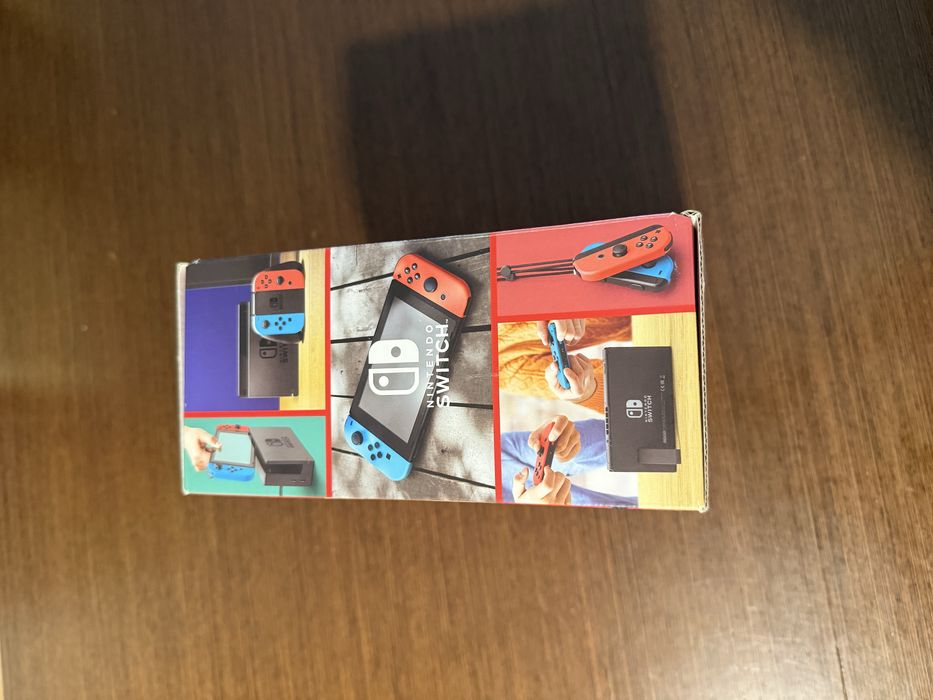 Vendo Nintendo Switch clássica com comandos Joy-Con azul e vermelho, em estado novo.