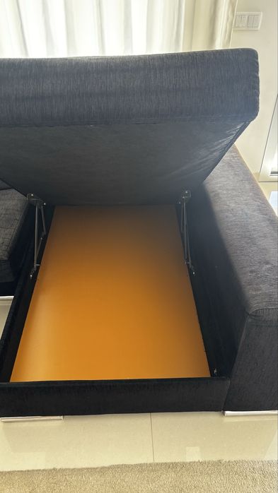 Sofá preto com chaise longue e arrumos