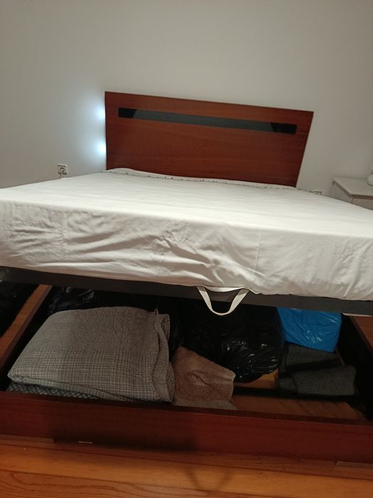 Cama grande de casal, com arrumação.