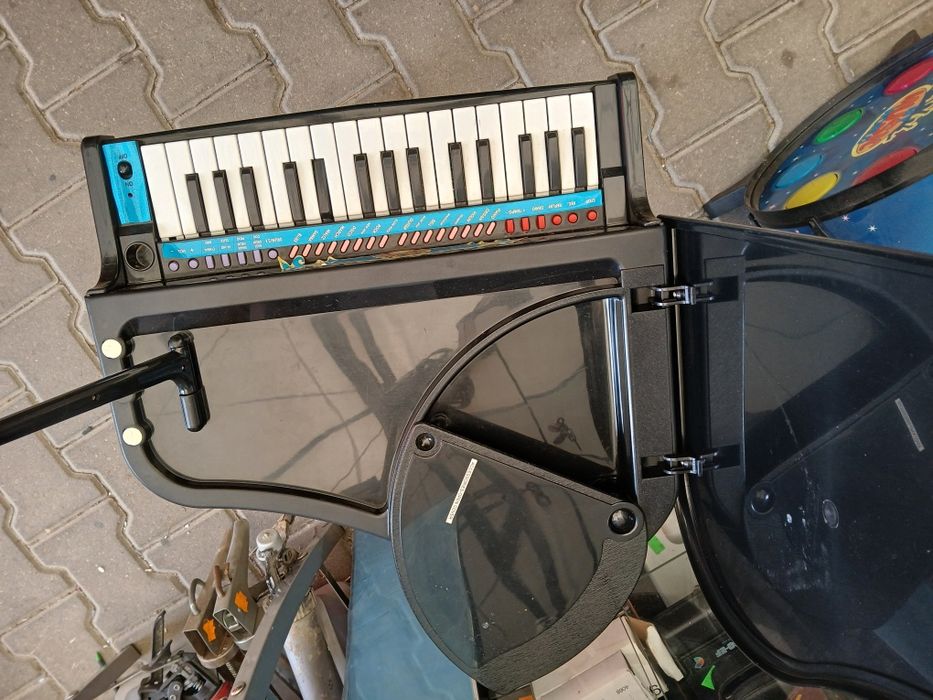 czarne, plastikowe pianino-zabawka w kształcie mini fortepianu