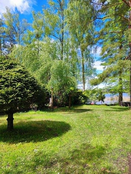 Domek nad jeziorem --- Majdy (Olsztyn) z linią brzegową i pomostem.