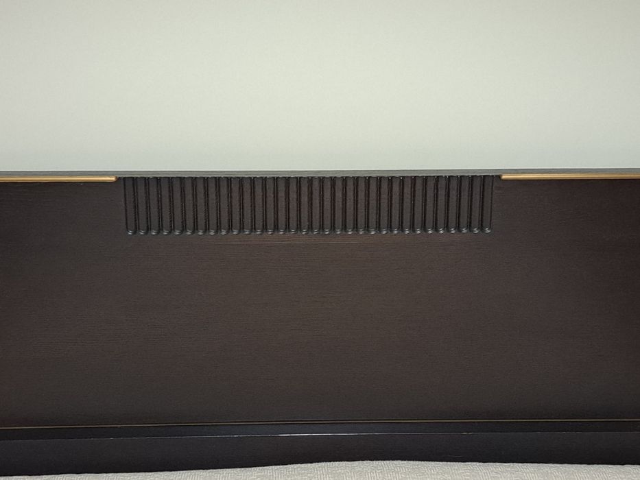 Cama de casal,  cor castanho escuro, com iluminação.